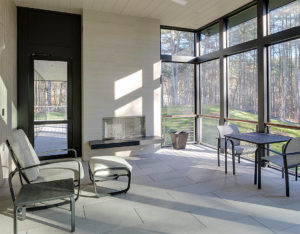 contemporary bedroom with fireplace and large windows