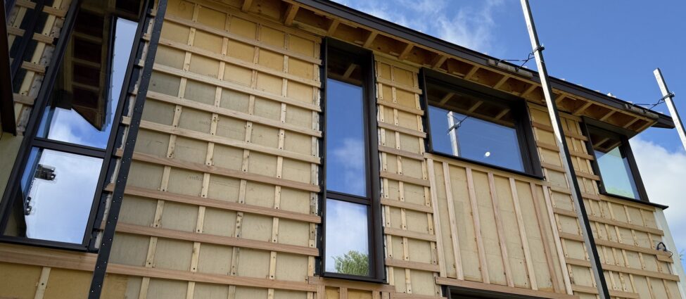 High-performance home under construction in eastern Massachusetts, exterior walls wrapped in Steico Universal Dry wood fiber board with wood rainscreen battens and cross-strapping