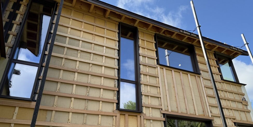High-performance home under construction in eastern Massachusetts, exterior walls wrapped in Steico Universal Dry wood fiber board with wood rainscreen battens and cross-strapping