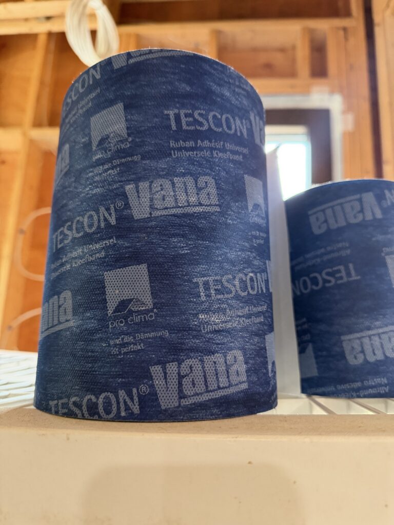Rolls of Pro Clima Tescon Vana air-sealing tape on a window sill at a high-performance construction site